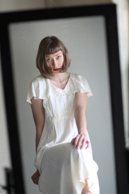 Güzel kadın beyaz bir elbise aynaya yansıyan