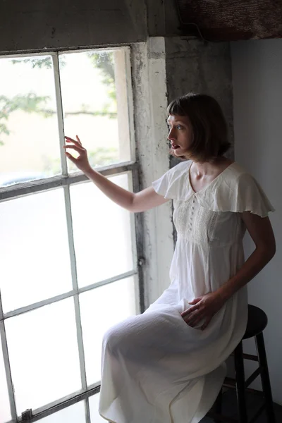 Mujer hermosa en un vestido blanco en la luz de la ventana —  Fotos de Stock