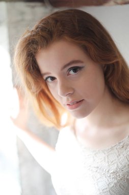 Bej renkli elbiseli kırmızı saçlı kadın