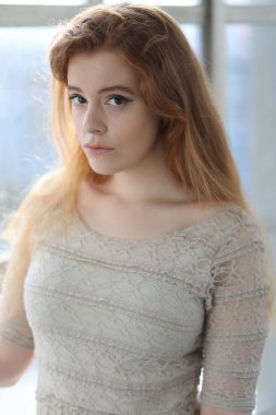 Bej renkli elbiseli kırmızı saçlı kadın