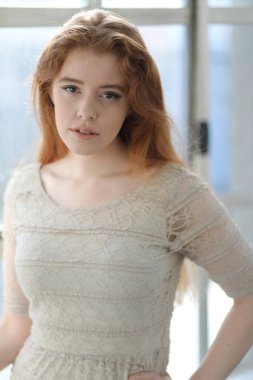 Bej renkli elbiseli kırmızı saçlı kadın