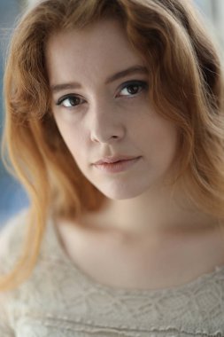 Bej renkli elbiseli kırmızı saçlı kadın