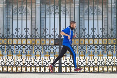 Madrid, İspanya - 22 Mayıs 2020: Genç adam Madrid Kraliyet Sarayı 'nın kapısında spor yapıyor