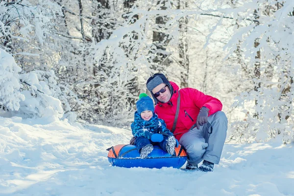 快乐的幼儿男孩与爸爸在白雪皑皑的丛林 图库图片