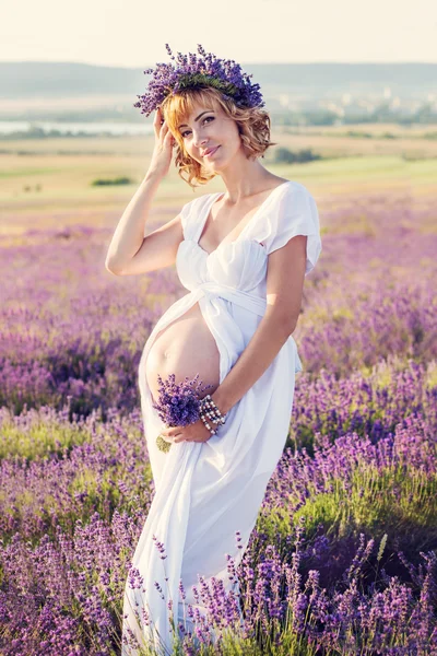 Schöne schwangere junge Frau in einem weißen Kleid — Stockfoto