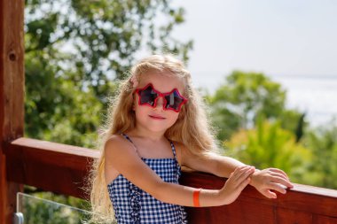 Sevimli küçük kız bir terasta eğleniyor