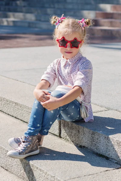 Bedårande liten flicka sitter på trappan — Stockfoto