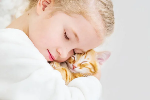 Bir yavru kedi üzerinde zencefil bir ele sahip sevimli küçük kız — Stok fotoğraf