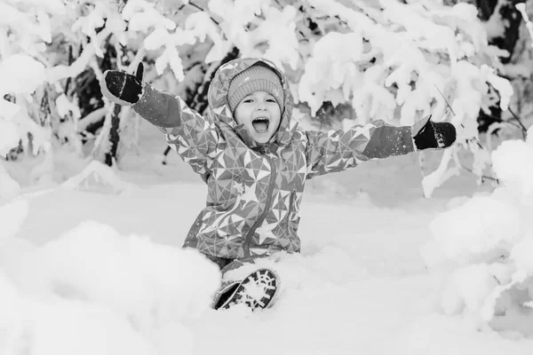 Счастливая маленькая девочка, играющая в снегу — стоковое фото