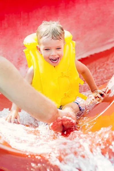 Liten pojke ner med vattenrutschbana — Stockfoto
