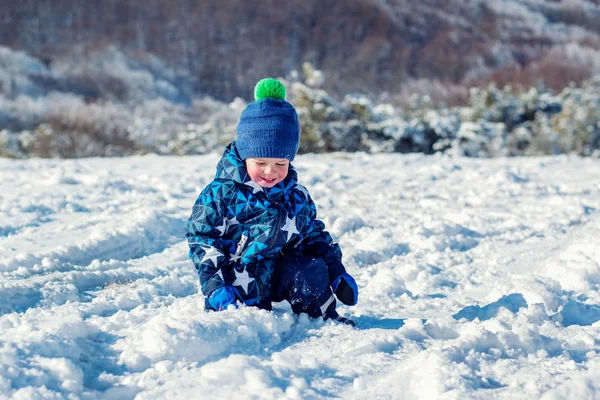 Gelukkig peuter cheeked kind raakt de sneeuw — Stockfoto