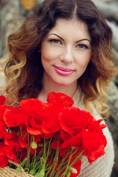 Beautiful young woman with a bouquet of poppies — Stock Photo, Image
