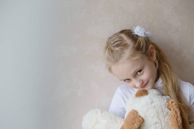 Küçük kız bir oyuncak köpek tutmak gülümseyen