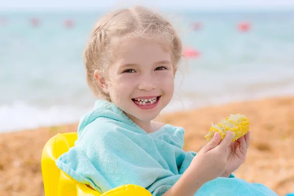 Porträtt av leende liten flicka äter majs — Stockfoto
