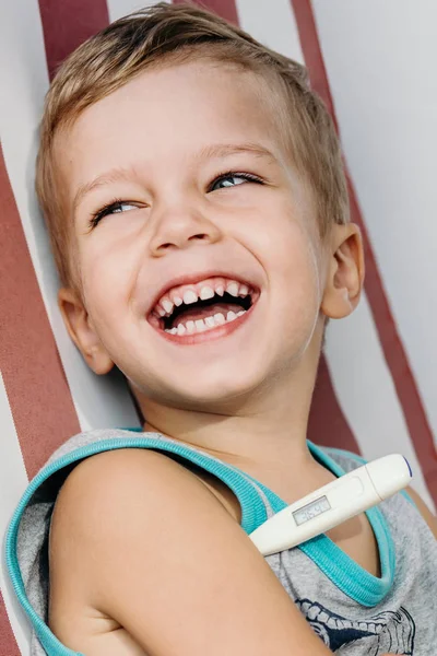 Glücklich lachender kleiner Junge misst Temperatur — Stockfoto