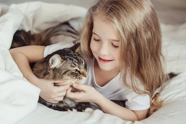 Encantadora niña abrazando a su gato — Foto de Stock