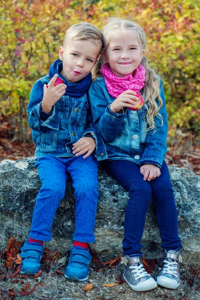 Menino e menina comendo maçãs — Fotografia de Stock