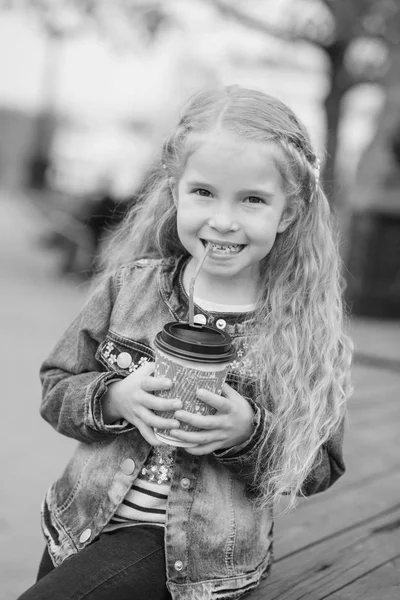 Gelukkig meisje drinken cacao uit het stro buitenshuis — Stockfoto