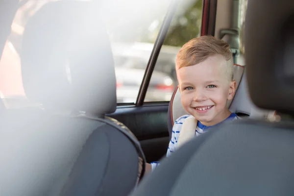 Portrait happy toddler boy sitting in the car — Stock Photo, Image