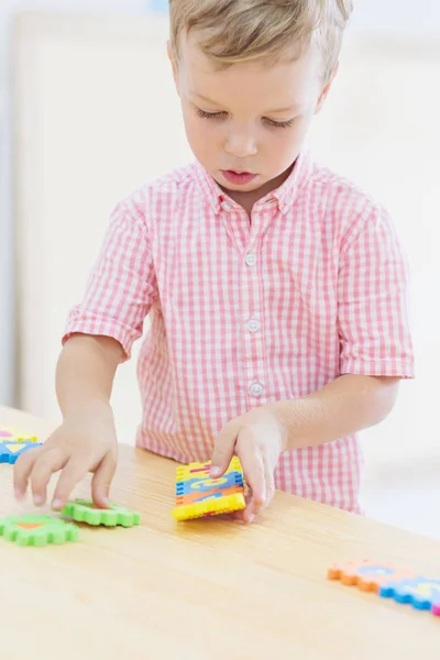 Focado bonito pequena criança coleta quebra-cabeças — Fotografia de Stock