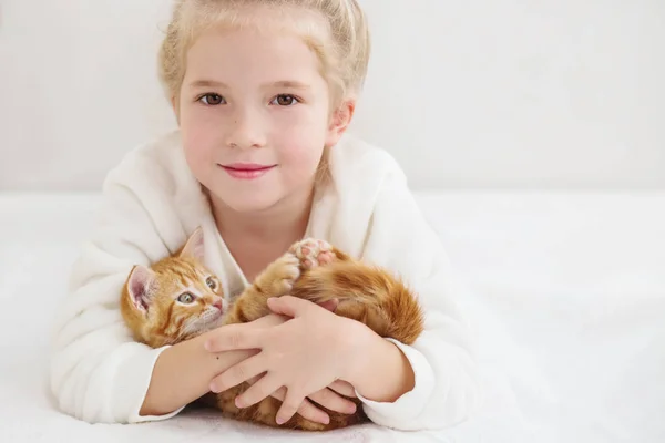 Χαριτωμένο μικρό κορίτσι που κρατά ένα γατάκι σε ένα χέρι τζίντζερ — Φωτογραφία Αρχείου