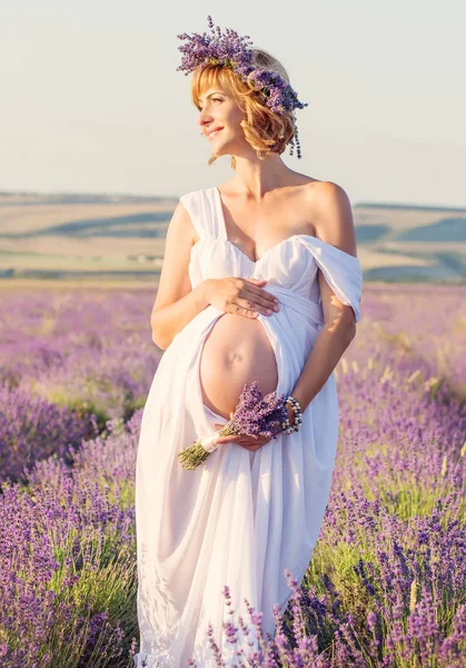 Schöne schwangere junge Frau in einem weißen Kleid — Stockfoto