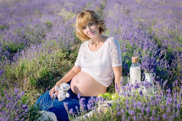 Mladá těhotná žena v poli levandule — Stock fotografie