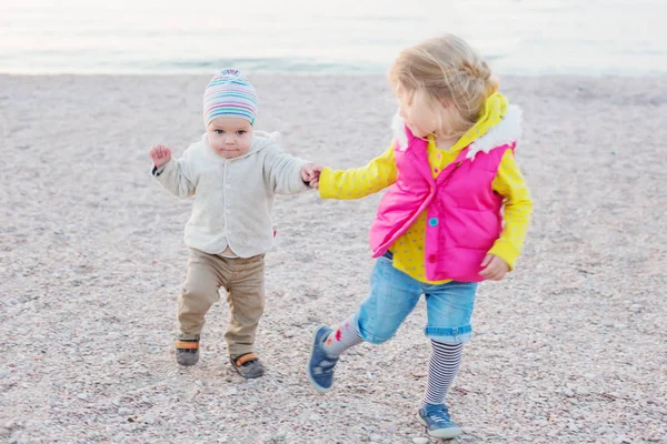 Little children, older sister teaches brother to walk — Stock Photo, Image