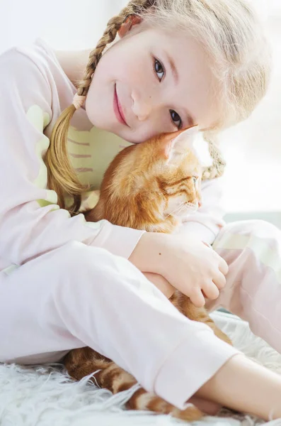 Linda niña sosteniendo un gatito en una mano de jengibre —  Fotos de Stock