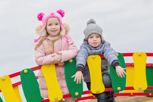 Feliz irmãozinho e irmã brincando em um playground — Fotografia de Stock