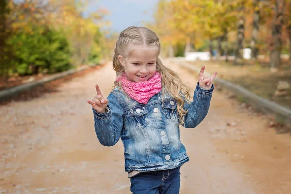 Linda niña haciendo un signo de rock-n-roll — Foto de Stock