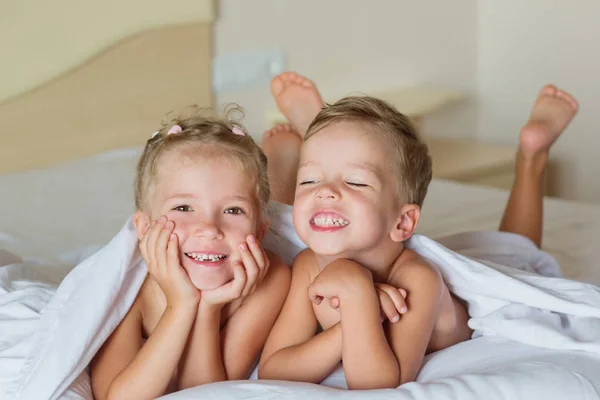 Sevimli çocuklar yatağa oynarken — Stok fotoğraf