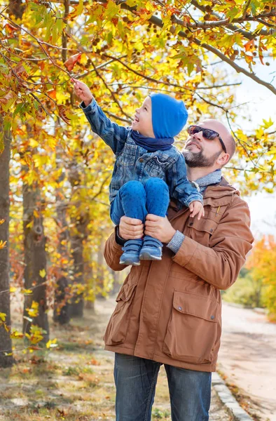 Отец носит сына на плече в парке — стоковое фото