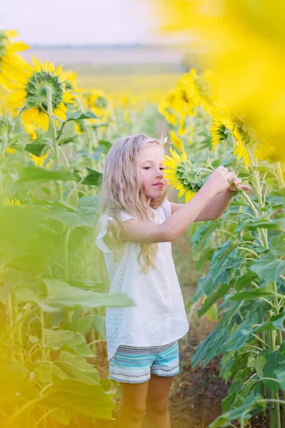 Hermosa niña admirando la flor —  Fotos de Stock