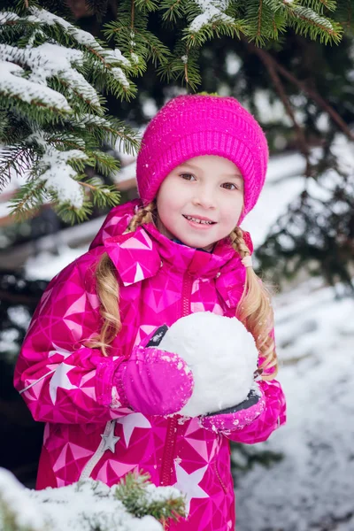 Schattig klein meisje in een forest met sneeuw bedekte beeldhouwt — Stockfoto