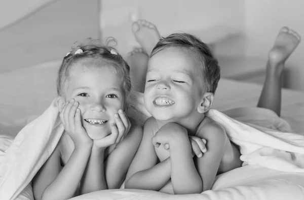 As crianças encantadoras brincando na cama — Fotografia de Stock