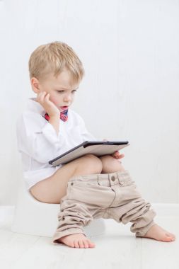 çömlek üzerinde tablet pc oynarken oturan yürümeye başlayan çocuk 
