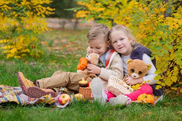 Dvě šťastné děti hrají v podzimní park — Stock fotografie