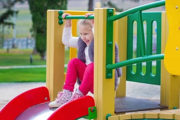 Mooi lachende meisje klimmen in een speeltuin — Stockfoto