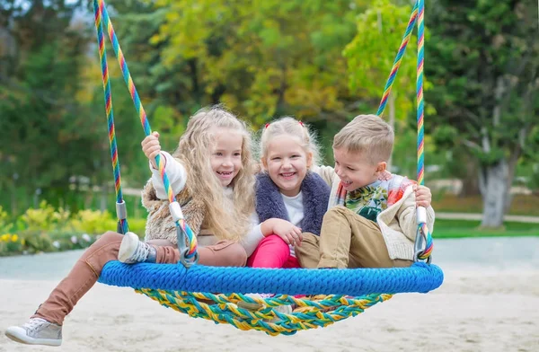 Três crianças brincando no parque — Fotografia de Stock