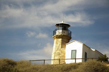 Eski bir deniz feneri Kıbrıs ve bulutlu mavi gökyüzü açık mimarisi