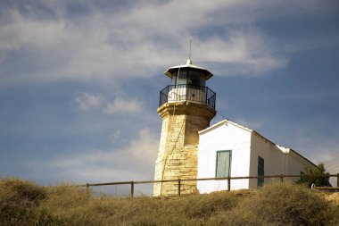 Eski bir deniz feneri Kıbrıs ve bulutlu mavi gökyüzü açık mimarisi