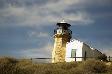Eski bir deniz feneri Kıbrıs ve bulutlu mavi gökyüzü açık mimarisi