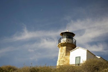 Eski bir deniz feneri Kıbrıs ve bulutlu mavi gökyüzü açık mimarisi
