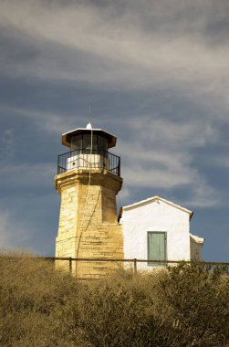 Eski bir deniz feneri Kıbrıs ve bulutlu mavi gökyüzü açık mimarisi