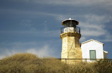 Eski bir deniz feneri Kıbrıs ve bulutlu mavi gökyüzü açık mimarisi