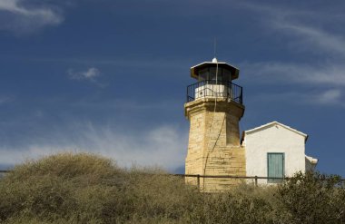 Eski bir deniz feneri Kıbrıs ve bulutlu mavi gökyüzü açık mimarisi