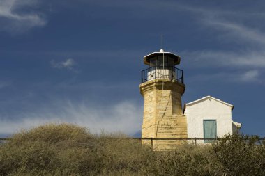 Eski bir deniz feneri Kıbrıs ve bulutlu mavi gökyüzü açık mimarisi