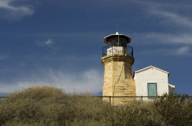Eski bir deniz feneri Kıbrıs ve bulutlu mavi gökyüzü açık mimarisi