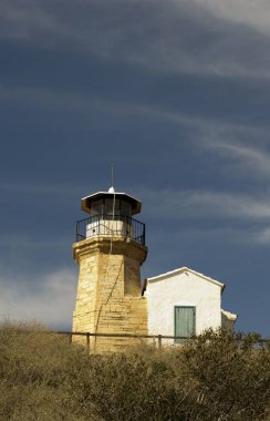 Eski bir deniz feneri Kıbrıs ve bulutlu mavi gökyüzü açık mimarisi